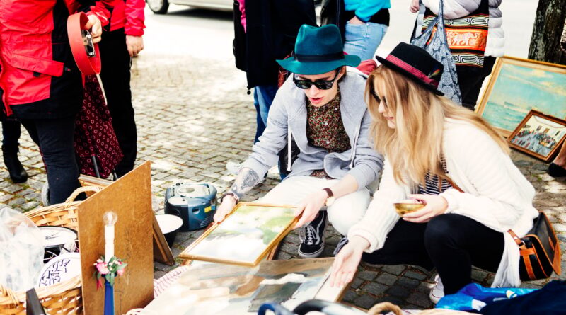 Friends choosing picture frames at flea market