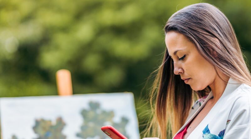 Painter using a mobile in a park