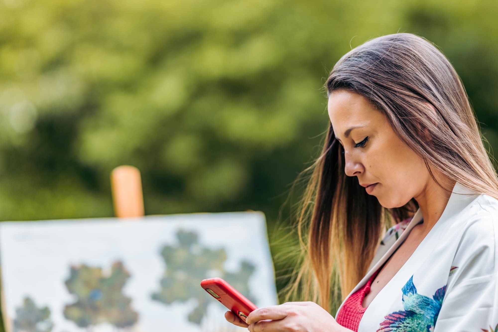 Painter using a mobile in a park