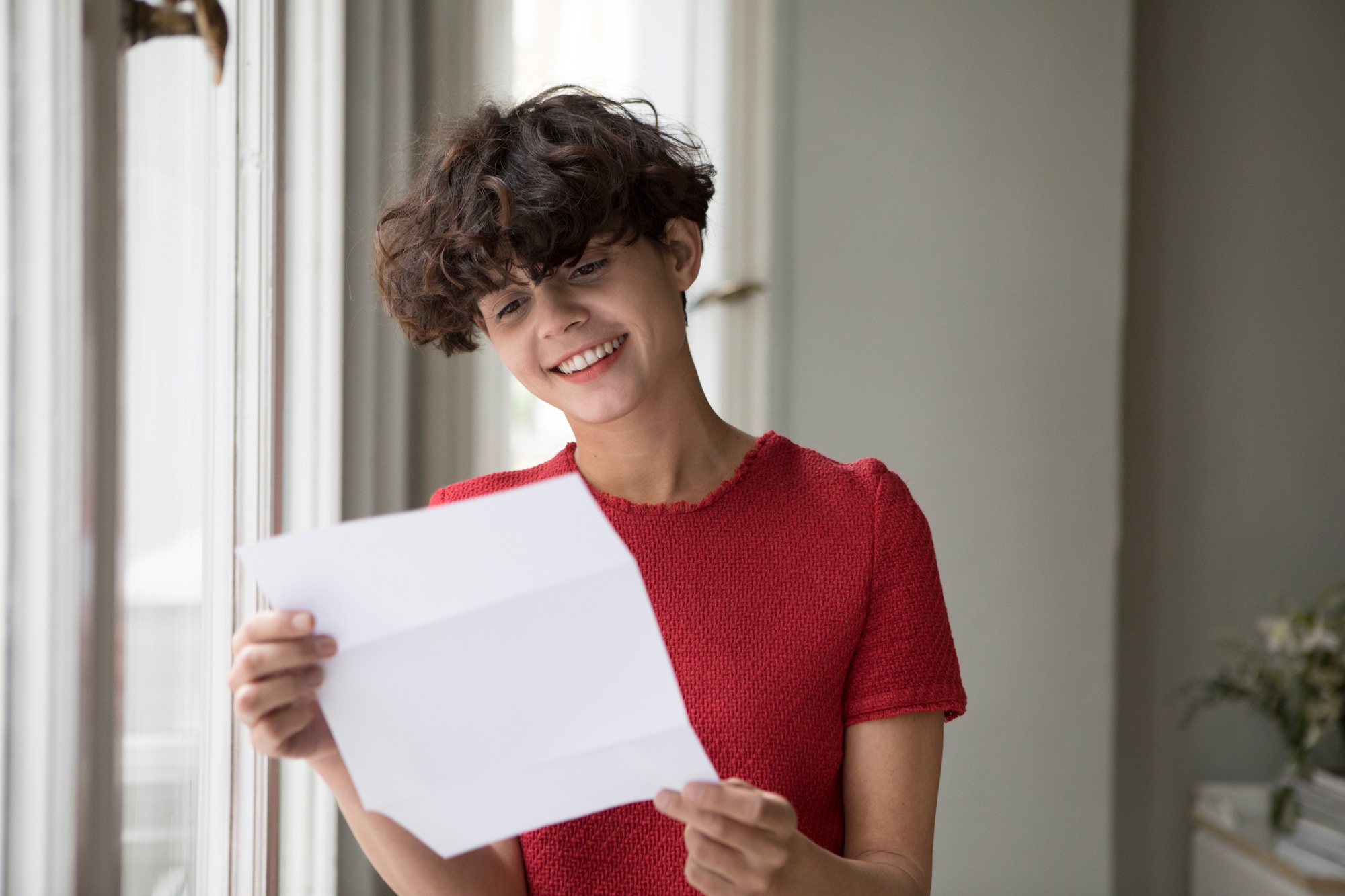 Portrait of smiling young woman reading a letter