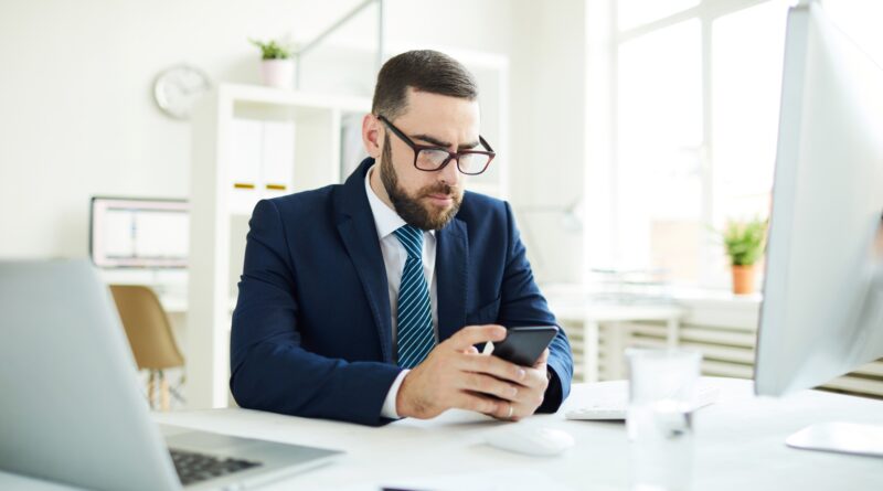 Businessman reading sms in office