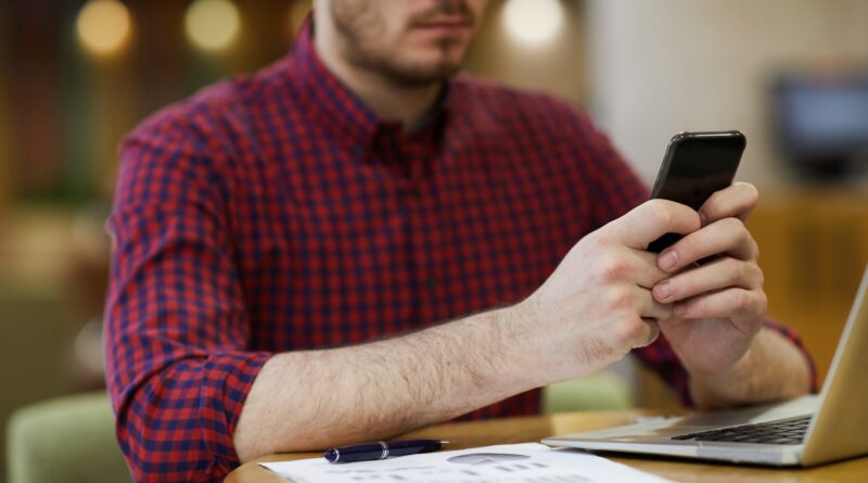 Busy financial adviser answering sms in cafe
